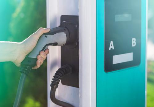 man unplugging electric charger from dock charge station