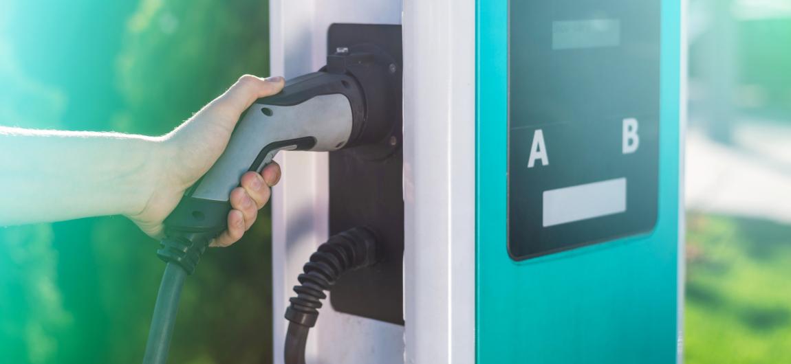 man unplugging electric charger from dock charge station